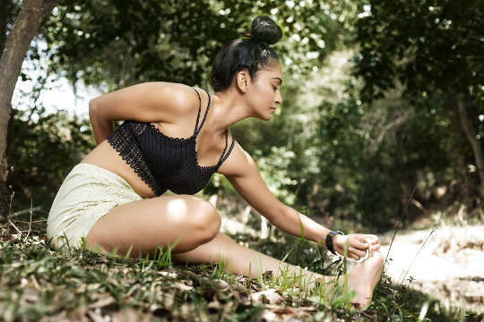 Wild Practices for Listening to the Intelligence of Your Body a woman in a seated yoga pose outside in nature