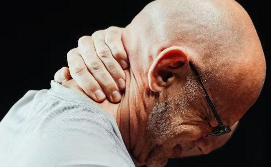 How to Retrain Your Brain When You Get Sensitized to Pain a man holding his neck in pain